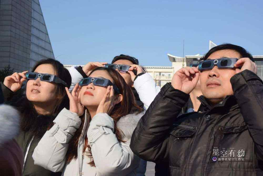 2019年12月26日，在天津科技馆，市民戴上专门观测太阳的眼镜观看日偏食。新华社发