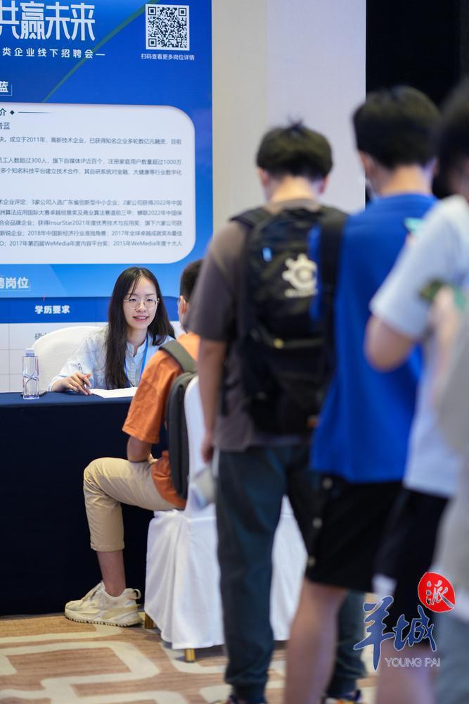 一家企业的摊位上,有不少求职者等待面试