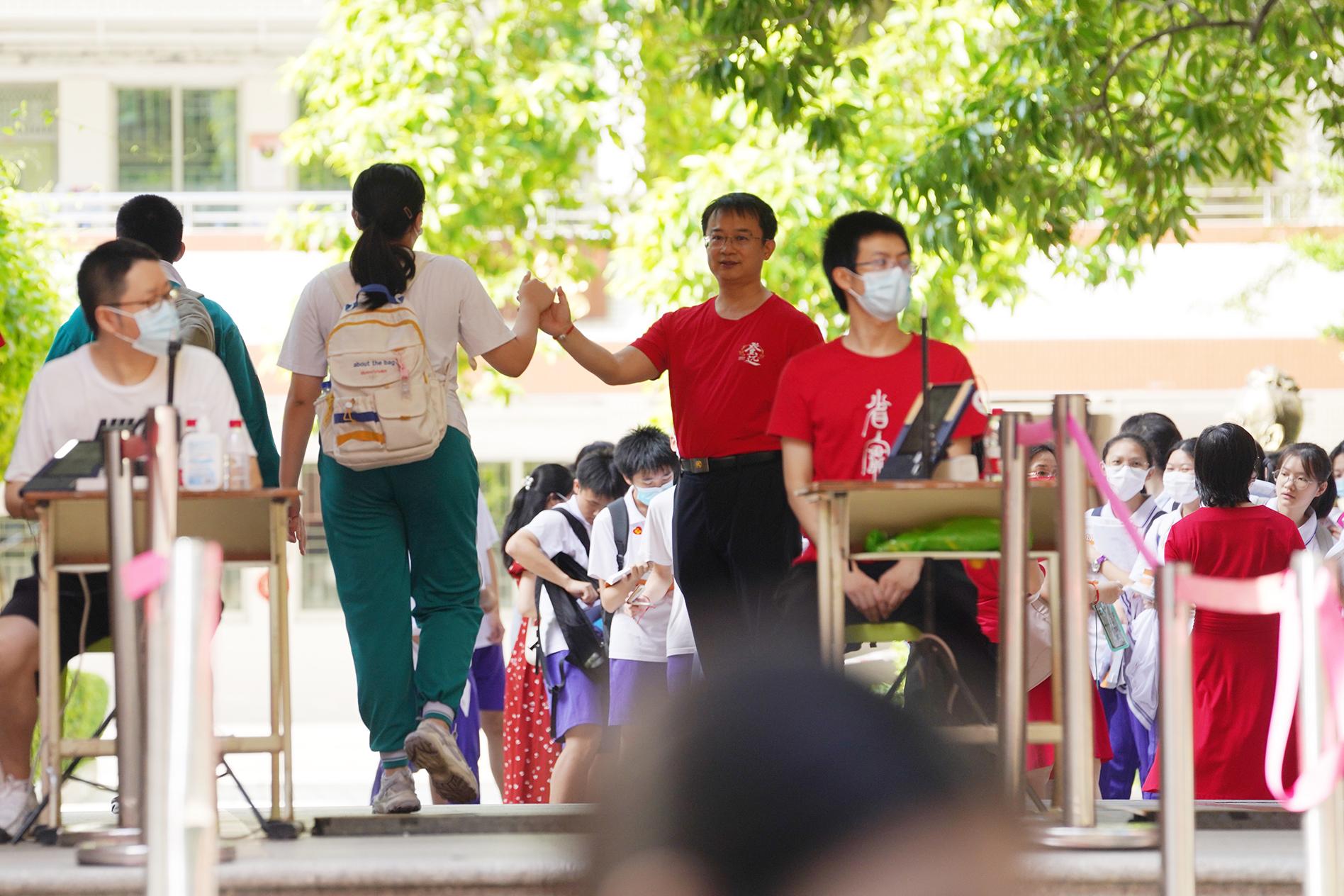 广东实验中学的老师与考生击掌祝福