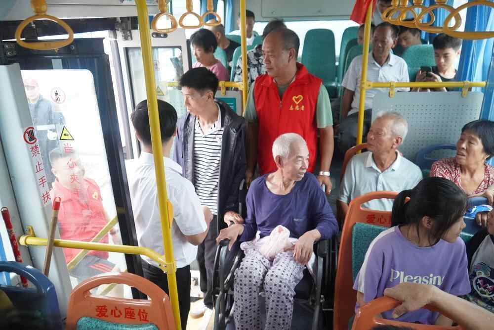 党员干部齐心协力帮助行动不便的老人上车,顺利完成转移工作