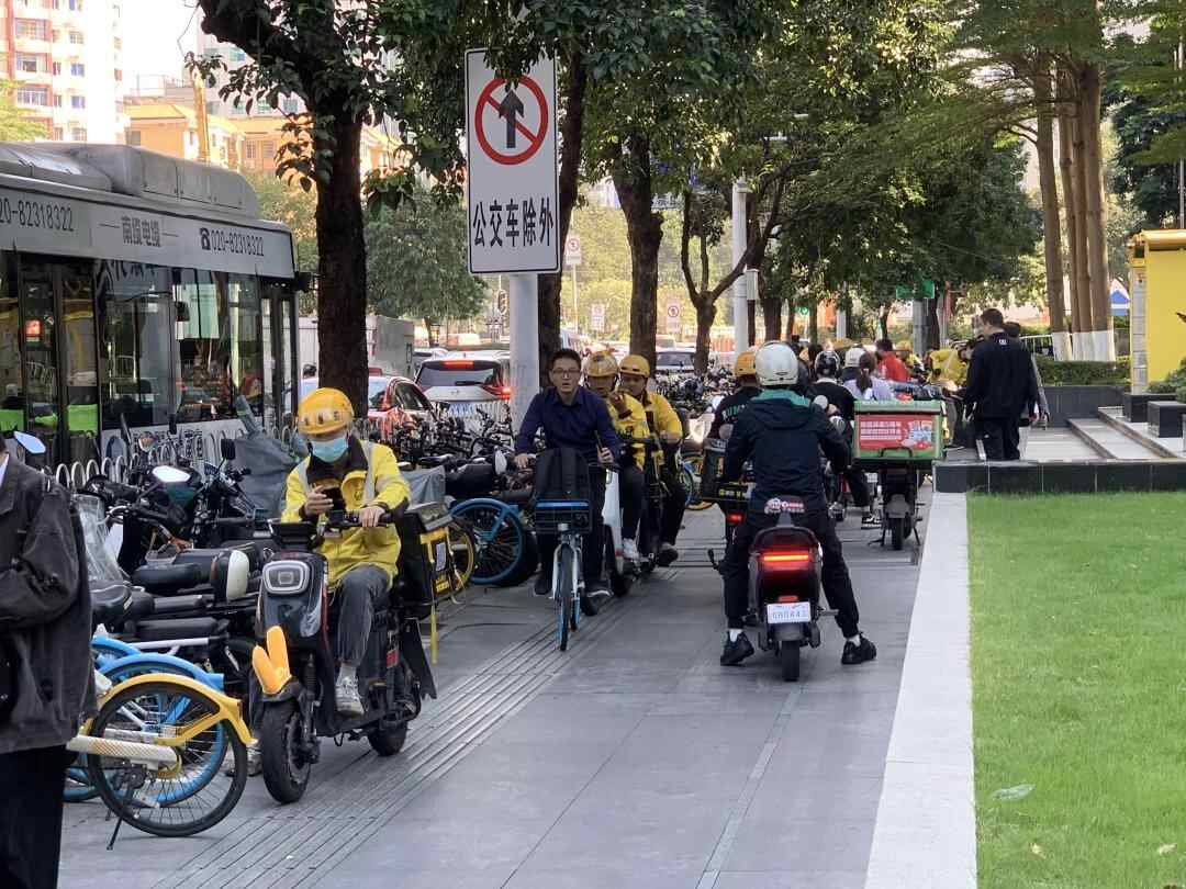外卖电动自行车、自行车在黄埔大道西的人行道上穿梭