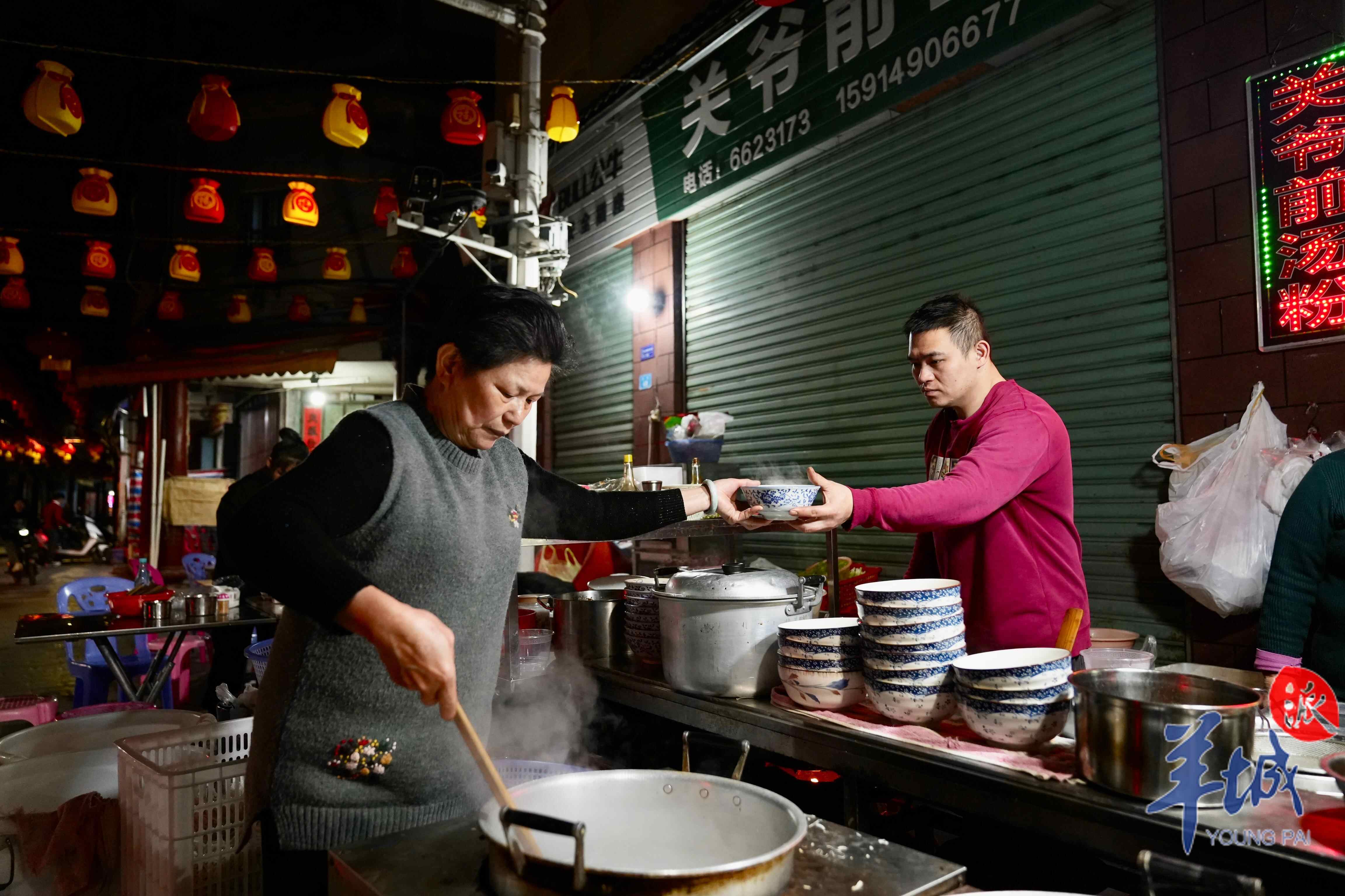 关爷前汤粉店前，陈晓武和妈妈一人捞粉一人烫肉，分工明确，配合默契，忙得不可开交