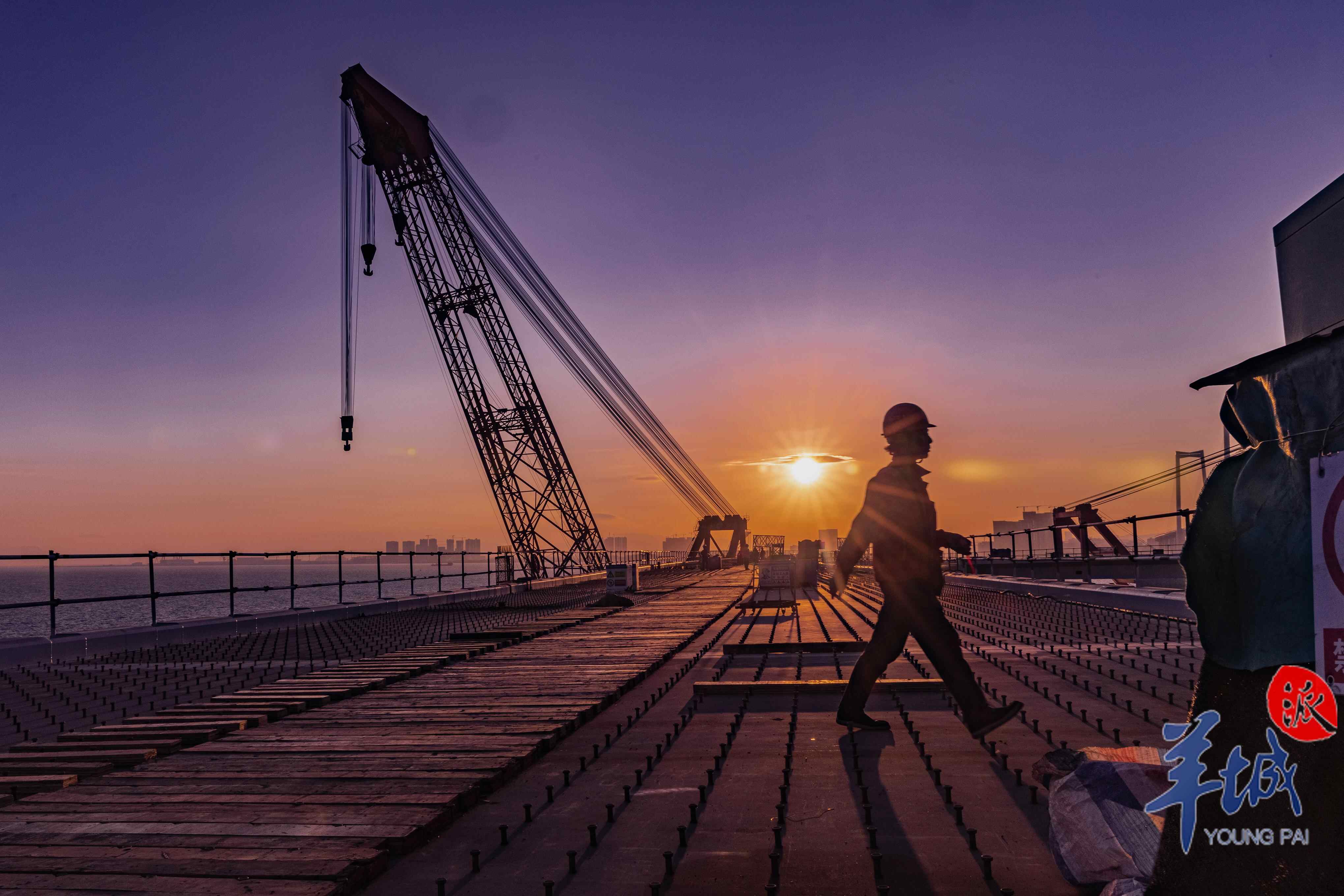 结束一天忙碌的桥面工作后,一名安全员在撤离施工现场时再一次检查桥面电闸是否关好后,披着晚霞下班去。黄金河拍摄于2023年12月