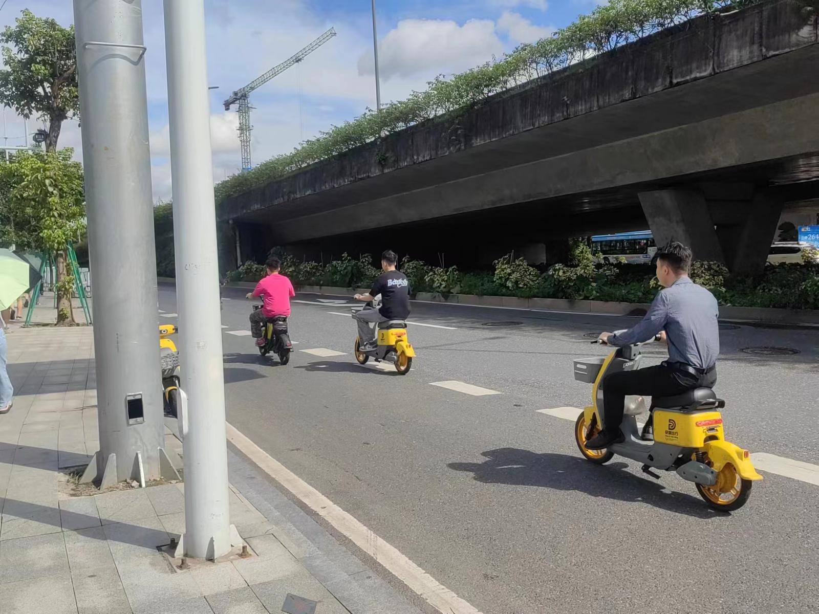  民众驾驶共享电动自行车，且均未佩戴头盔