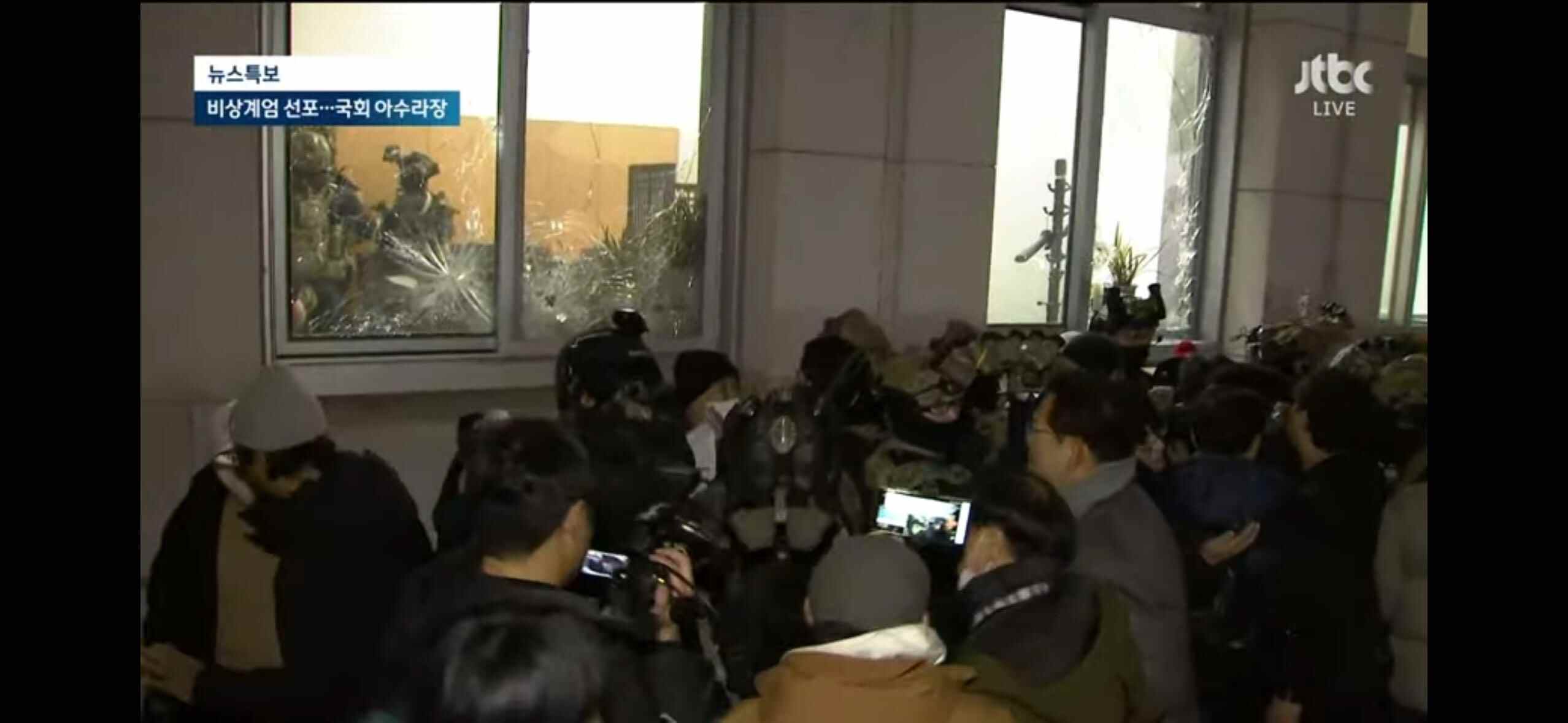 4日凌晨,戒严军试图进入国会逮捕参加会议的议员。图/央视新闻 4日凌晨,戒严军试图进入国会逮捕参加会议的议员。图/央视新闻